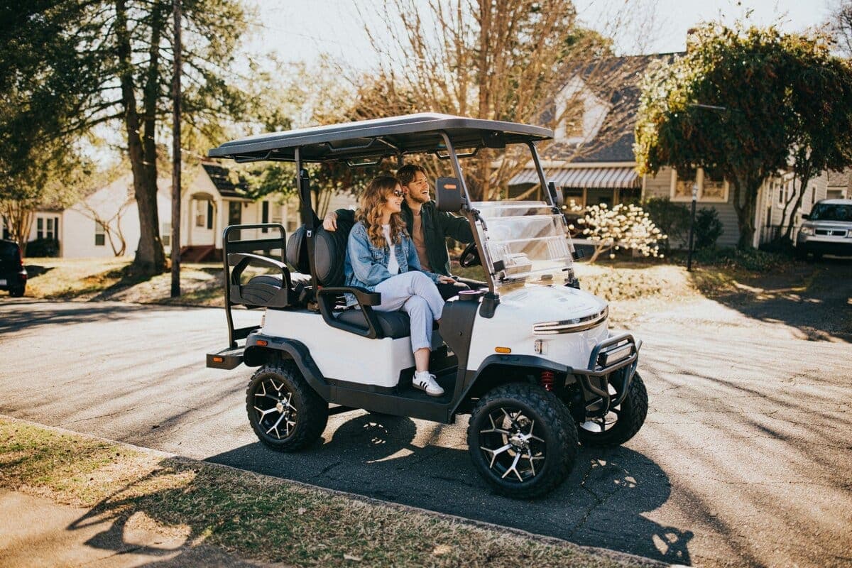 A couple riding a Denago Nomad XL golf cart at golden hour in the Shenandoah Valley